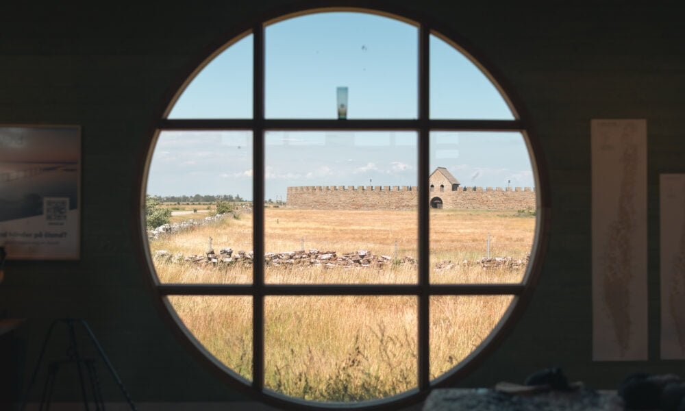 Stort runt fönster med vy över Eketorps borg.