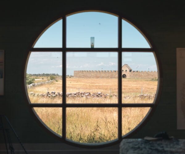 Stort runt fönster med vy över Eketorps borg.