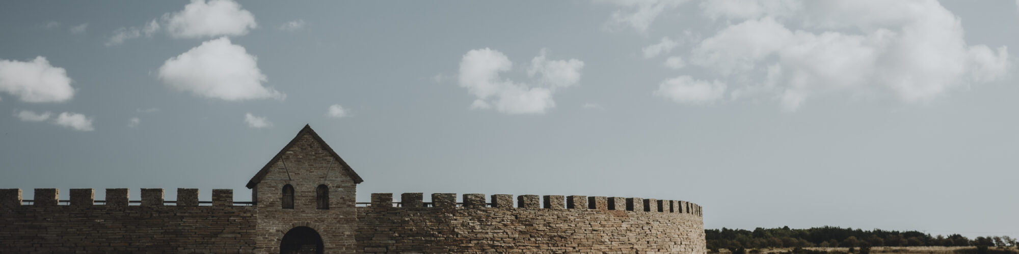 Eketorps borg på avstånd med betande får i förgrunden.